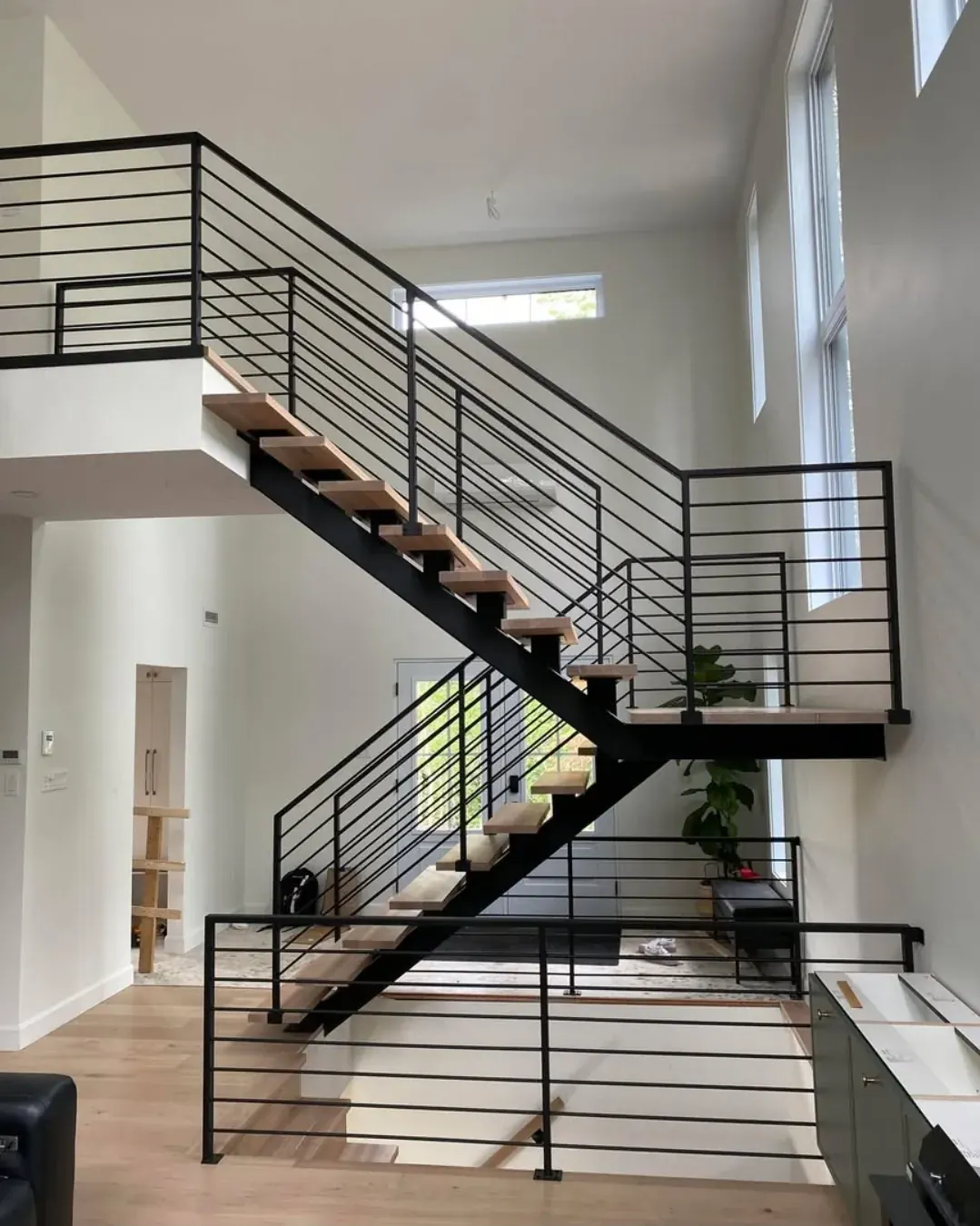 Escalier modulaire en chêne blanc, limon central acier noir et rampes horizontales acier, résidence moderne